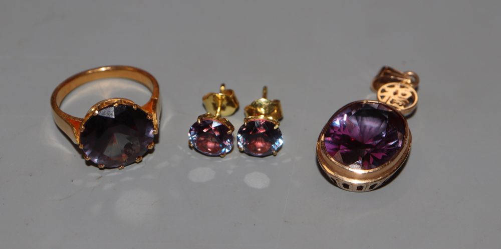 A 14k and synthetic colour change corundum pendant, a pair of similar earrings and a similar yellow metal dress ring, size M